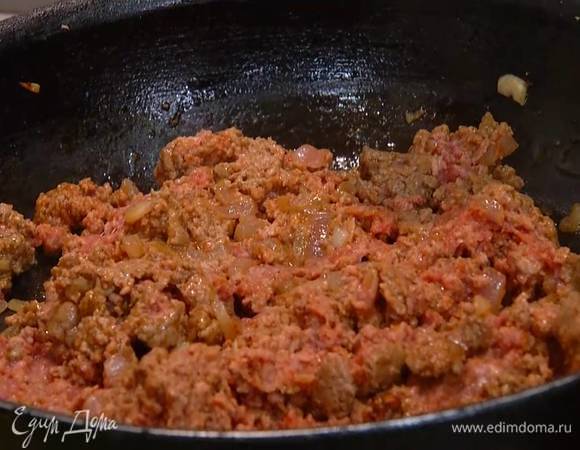 Приготовить начинку: разогреть в сковороде 2 ст. ложки оливкового масла, выложить лук и чеснок, добавить кориандр, зиру, сумах, все перемешать и обжарить лук до золотистого цвета, затем добавить 1 ч. ложку томатный пасты и фарш, размять мясо лопаткой и обжарить до полуготовности.