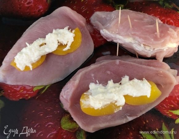 Разрезать куриные грудки так, чтобы образовался кармашек. В него кладем половинки персиков и сырную начинку. Скрепляем зубочистками. Выкладываем в форму, смазанную маслом, грудки и картофель, нарезанный пополам. Запекаем в духовке 40 минут при температуре 180°С.