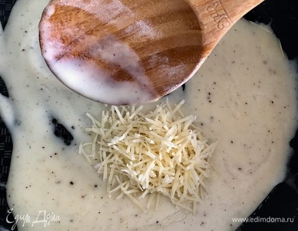 Пару минут даем соусу остыть и прямо на сковороду вводим половину натертого пармезана, перемешиваем.