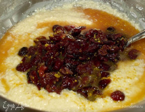 Соединить масляную и яичные смеси. Взбить до однородного состояния с добавлением двух столовый ложек муки. Добавить смесь вяленой клюквы, апельсиновой цедры и свежевыжатого апельсинового сока. Все тщательно размешать. 