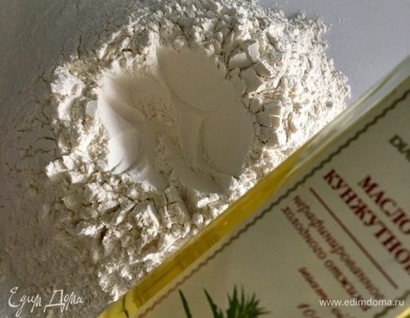 В центре муки сделать углубление-колодец. Влить в него 3 столовые ложки кунжутного масла.