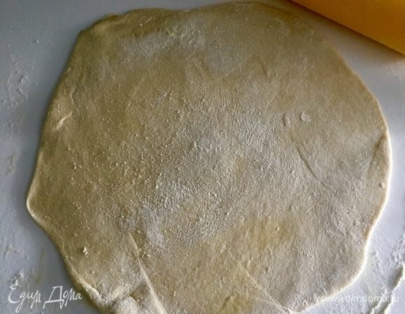 Через 30 мин. займемся отдохнувшим тестом. Рабочую поверхность припылить мукой. Положить на нее шар теста и с помощью скалки раскатать его в круг диаметром 25 см.