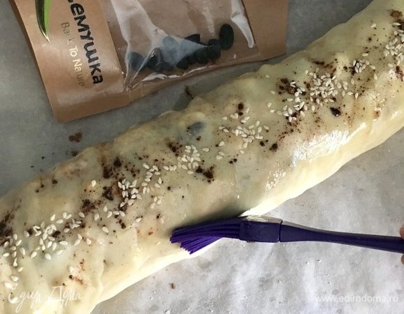 С помощью полотенца свернуть плотный рулет, защипнув края. Поверхность штруделя смазать маслом, посыпать немного сахаром, корицей и обязательно кунжутом. С помощью полотенца перенести штрудель на противень, застеленный пекарской бумагой. И отправить в разогретую до 200°С духовку на 35–40 мин., пока рулет не зарумянится.