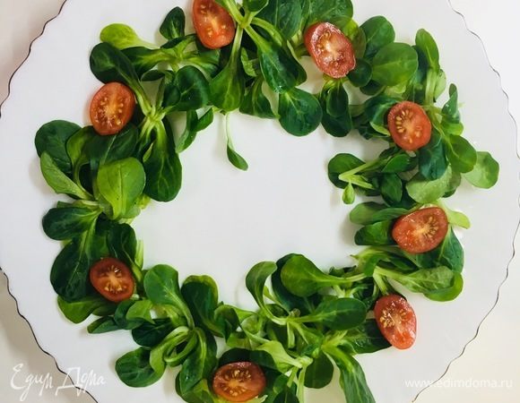 На салат выкладываем помидоры черри, предварительно разрезанные на две части.