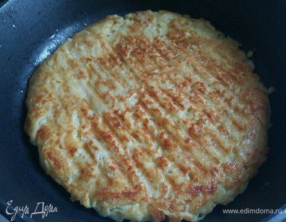 Как увидите, что нижняя сторона теста обжарилась, кладете сверху плоскую тарелку, немного меньше диаметром, чем сковорода, и переворачиваете на тарелку картофельный блин. Затем сразу же с тарелки возвращаете картофельный блин на сковороду необжаренной стороной. И жарьте вторую сторону также 5–7 минут.