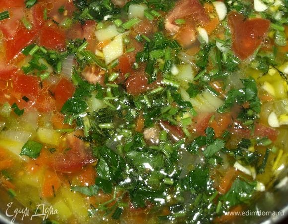 Добавить в кастрюлю помидоры, стебли зелени, чеснок и варить до мягкости картофеля.