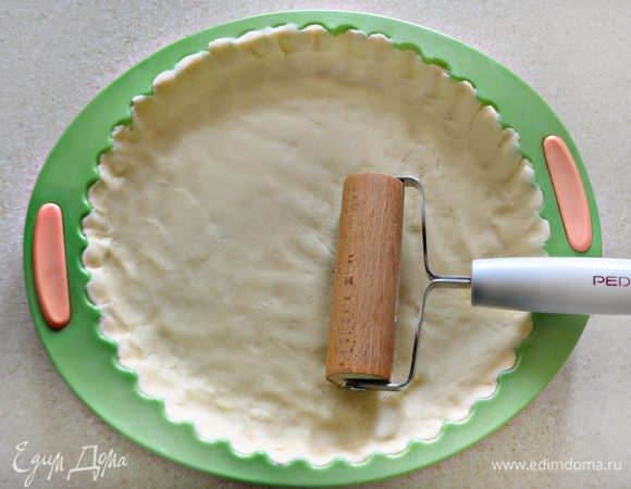 Форму для выпечки (у меня d=24 см) смажьте сливочным маслом. Из теста сформируйте небольшую лепешку и раскатывайте с помощью специального валика прямо в форме. Делайте это аккуратно, поскольку тесто легко рвется. Затем форму с тестом необходимо убрать в холодильник на 30 минут.