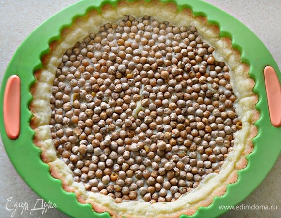 В форму с тестом насыпьте горох (нут или бобы), поставьте в разогретую духовку на 10 мин. После чего выньте бобовые и верните форму с тестом снова в духовку на 5 мин.
