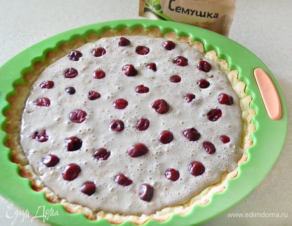 Начинку равномерно выложите на основу, сверху распределите вишню (ягоды предварительно необходимо разморозить). Выпекайте тарт в духовке при 180°С примерно 45 мин. Начинка должна быть плотной.