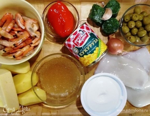 Подготовьте все ингредиенты. Креветки разморозить и очистить от панцирей (не выбрасывать), кальмары разморозить и очистить от внутренностей. Из кукурузы ТМ «Фрау Марта» слить жидкость. Перец, оливки, лук нарезать. Кальмары и креветки отварить в течение 3 минут.