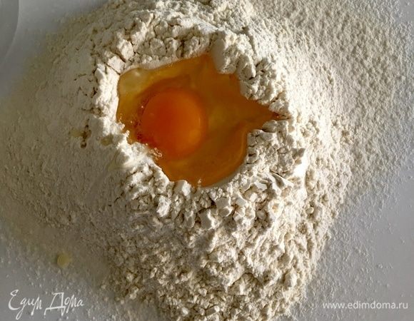 В центре холмика из муки сделаем углубление, в которое вобьем яйцо.