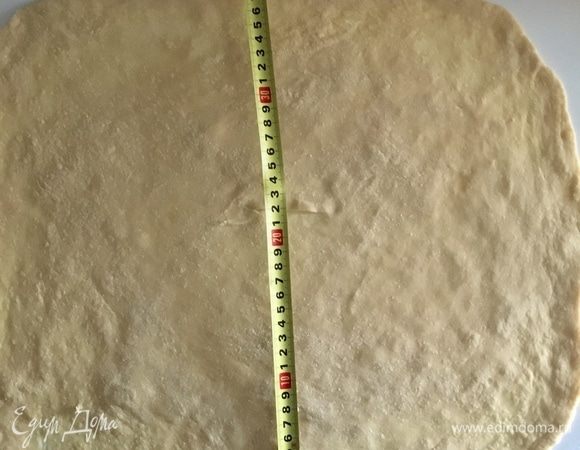 Возвращаемся к тесту. Припылив мукой рабочую поверхность сначала скалкой раскатываем тесто в круг примерно 25 см в диаметре. Затем подсовываем руки ладошками вниз под тесто, слегка сгибаем пальцы и тыльной стороной ладони начинаем растягивать тесто от центра к периферии. Когда почувствуете, что центр достаточно растянут, начинаем пальчиками растягивать края, формируя прямоугольник. Постепенно и потихоньку растягиваем, участок за участком, у меня получился прямоугольник 50/40 см примерно.