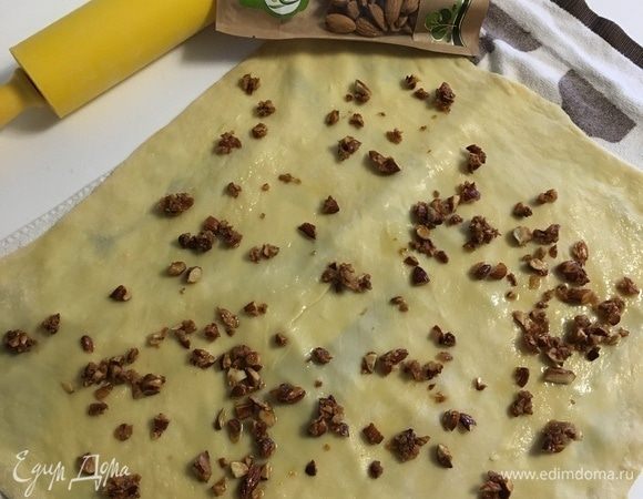 Пока я растягивала тесто, я перенесла его на кухонное полотеце, смазала слегка растительным маслом. Теперь присыпать карамельным миндалем.