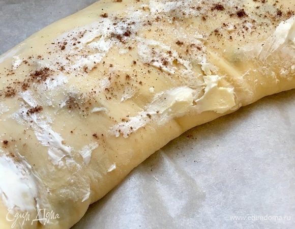 С помощью полотенца свернуть плотно в рулет и аккуратно перенести на пергамент швом вниз. Края защипнуть. Поверхность смазать растаявшим сливочным маслом, припудрить сахарком и корицей. Отправляем противень в заранее разогретую до 200°С духовку, минут на 35-40. 
