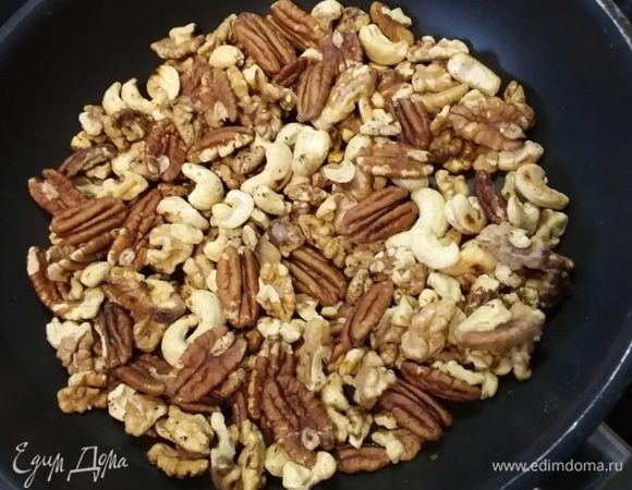 Орехи (в оригинальном рецепте грецкие, у меня — микс из грецкого, пекана и кешью) обжарить на сухой сковороде, остудить и порубить. Орехи смешать с корицей и коричневым сахаром.  Изюм замочить на час в роме или в чае. Яблоки очистить и нарезать на тонкие  дольки. 