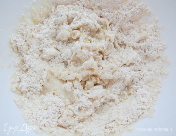 Готовим ушки. Рис отвариваем до полуготовности согласно инструкции на упаковке. В миску вливаем кипяток, кладем соль и всыпаем муку. Вымешиваем крутое не липнущее к рукам тесто. При необходимости подсыпаем еще муки.