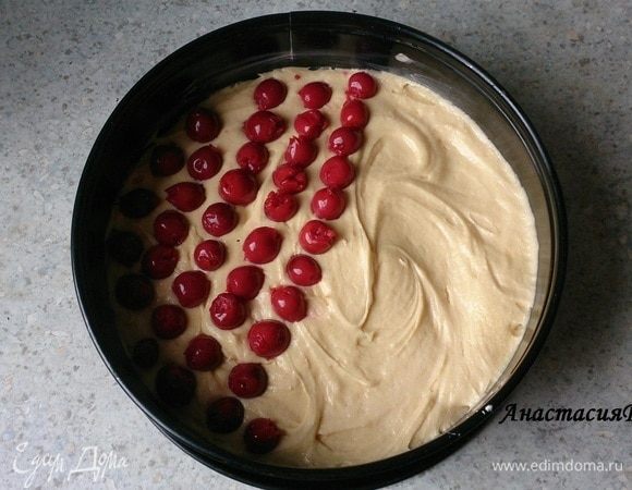 Тесто выкладываем в разъемную форму 24 см, предварительно смазанную маслом. Выравниваем. Сверху распределяем вишни и немного их вдавливаем в тесто.