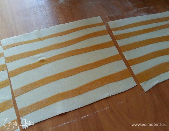 Прокатать скалкой, чтобы полосочки как бы впечатались в белое тесто. Нарезать на несколько пластов, для удобства. 