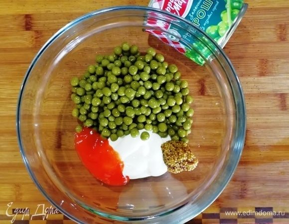 Слейте жидкость из зеленого горошка ТМ «Фрау Марта», добавьте майонез, острый перечный соус, горчицу.