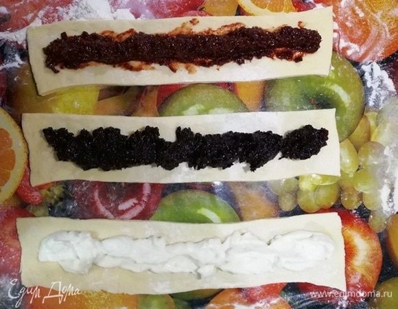 Остальную часть теста раскатываем и делим на 3 полосы. Посередине каждой полосы выкладываем начинку.