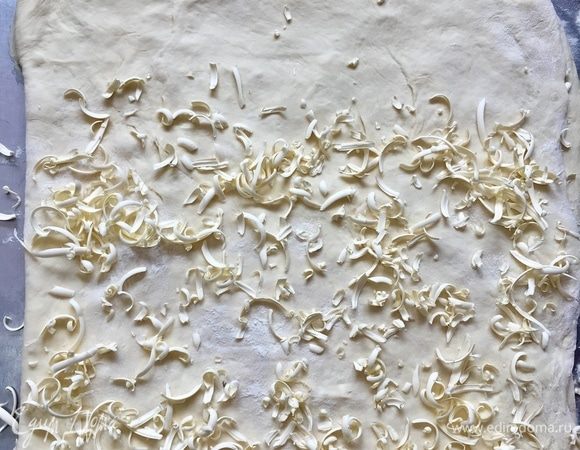 Раскатав прямоугольник, опять мысленно делим пласт на две части, на одну из них натираем масло и прикрываем второй половиной. Далее — масло и накрыли.