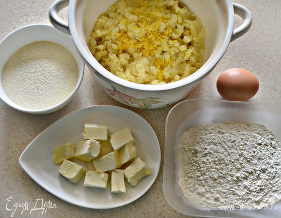 Картофель смешать с мукой, сахаром, манкой, желтком (белок оставить), половиной размягченного сливочного масла, цедрой половины лимона и все хорошо перемешать.