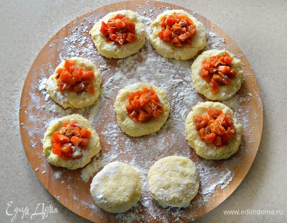 Тесто разделить на небольшие кусочки, размять в лепешку, на середину каждой выложить начинку — курагу. Защипать края и сформировать кнедли.