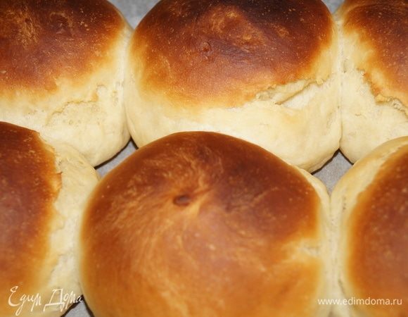 После того, как тесто поднялось, делим его на две части, раскатываем две колбаски и каждую колбаску делим лопаткой на 6 частей (получается 12 булочек). Из кусочков теста скатываем руками ровные шарики (благодаря р. маслу тесто будет легко скатываться в колобки), выкладываем их на противень, застеленный пекарской бумагой. Даем подняться минут 20, смазываем желтком с сахаром (можно смазать просто р. маслом после выпекания).