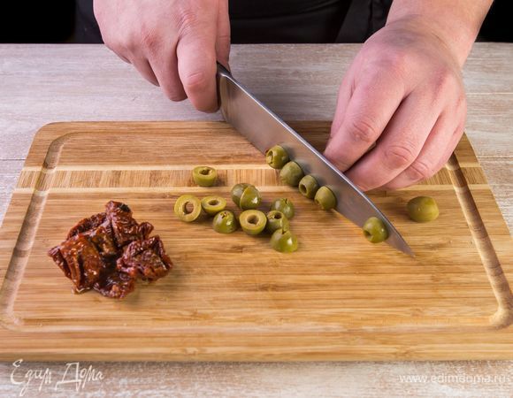 Нарежьте вяленые томаты и оливки пополам.