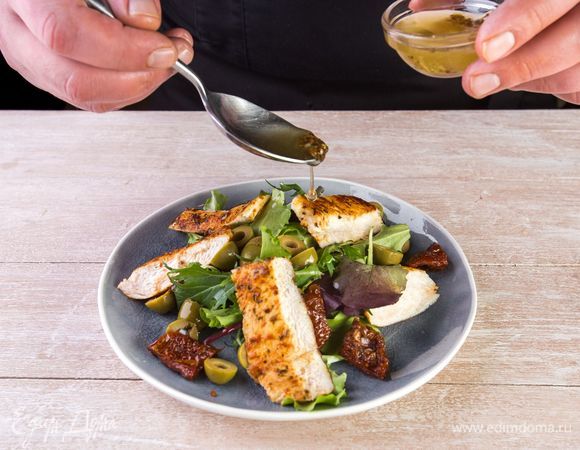 Выложите на тарелку салатные листья, а на них горкой все ингредиенты. Полейте соусом.