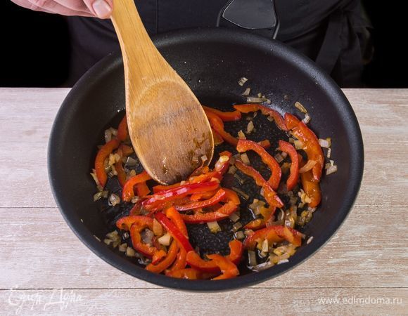 Обжарьте лук с чесноком и сладким перцем на сковороде до размягчения. Добавьте к овощной зажарке ломтики филе и стручковую фасоль. Снимите с огня.