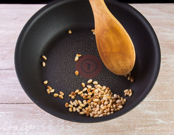 Подрумяньте на сухой сковороде кедровые орехи.