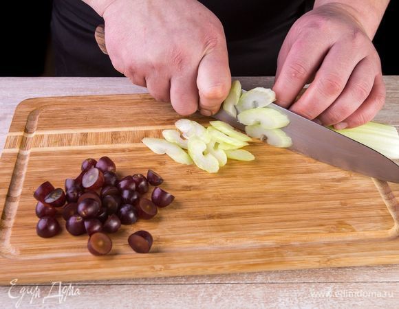 Нарежьте виноград на половинки, а стебли сельдерея — косыми ломтиками.