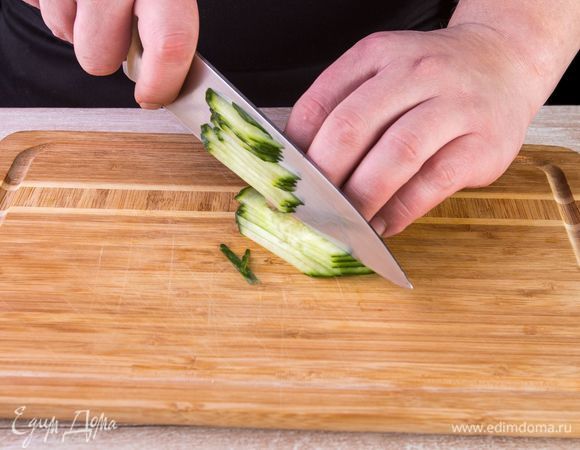 Нарежьте огурцы тонкой соломкой.