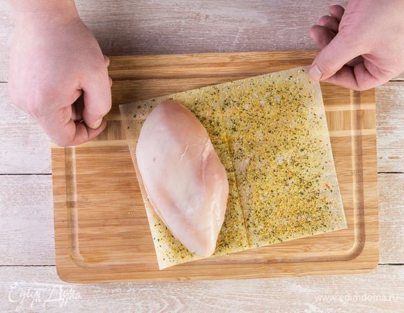 Положите отбитое филе на половину листа MAGGI®, закройте второй половиной и прижмите рукой.