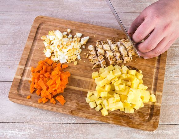 Нарежьте картофель, морковь, яйца и куриное филе одинаковыми кубиками.