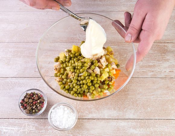 Заправьте оливье майонезом, посолите и поперчите по вкусу. Украсьте зеленью.