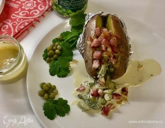 Можно сервировать блюдо. Разворачиваем фольгу. Картофель разрезаем пополам, но не до конца. Раскрываем картофель, в самую серединку добавляем соус — нежный, сочный, свежий, с намеком на лето. А сверху — мясную начинку! Бархатный вкус запеченной картошечки идеально оттеняется сливочным соусом. Нотка ветчины вносит немного копченого аромата. Все вместе очень вкусно! 