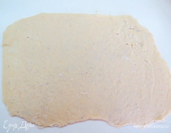 Складываем тесто пополам и раскатываем скалкой пласт толщиной 2–3 мм. На тесте будет виден рисовый рельеф.