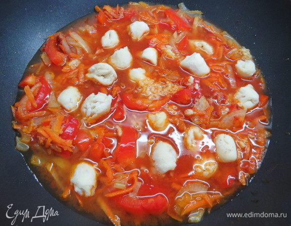 К овощам выкладываем «медвежьи ушки», вода должна покрывать содержимое сковороды полностью, приправляем свежемолотым черным перцем, выдавливаем через чеснокодавку чеснок. 