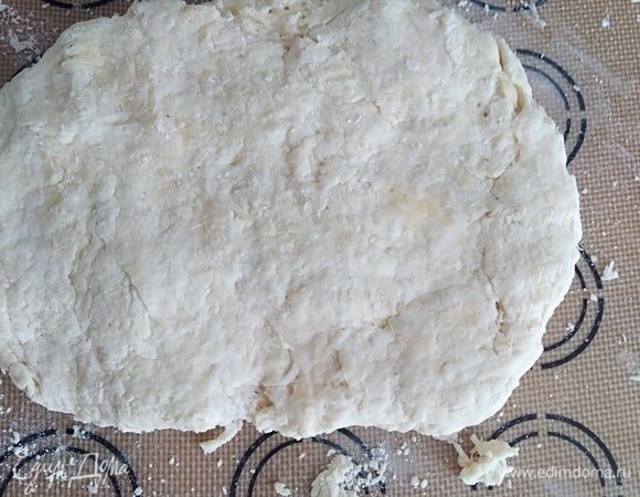 Влить яйцо и кефир. Быстро замесить тесто. Для сконов тесто не вымешивают долго, чтобы булочки были пышными. Если нужно, припылите руки мукой. 