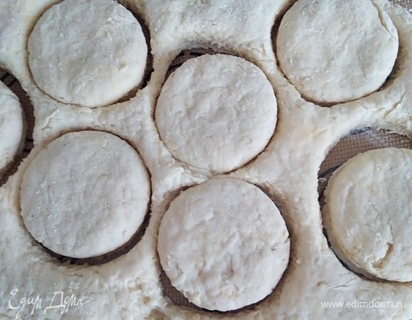 Руками распределить тесто в пласт толщиной около 2 см. Можно раскатать скалкой. Формочкой вырезать булочки. Оставшееся тесто снова собрать в комок и вырезать еще несколько штук. Получается около 12 булочек. Смазать верх булочек молоком и посыпать тертым сыром.