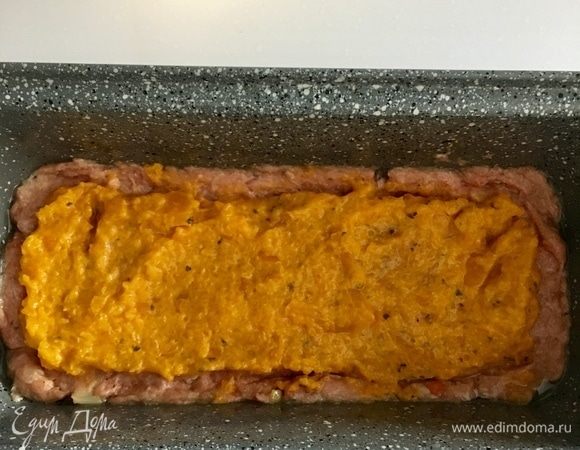Прямоугольную форму кирпичиком смазать немного растительным маслом. Фарш мысленно разделить на три части. Первую треть выложить в форму. Сверху распределить оранжевую начинку из болгарского перчика.