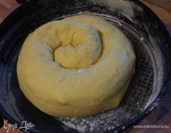 Свернуть в рулет, затем в улитку. Выложить в разъемную форму (у меня — 26 см в диаметре), посыпать мукой, затянуть пленкой и отправить в теплое место на 45 минут. 