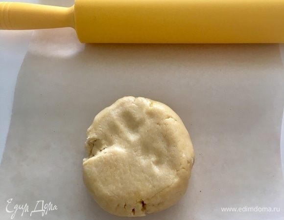 По истечении часа достать тесто из холодильника и между двух листов пекарской бумаги раскатать тесто в пласт толщиной 0,3 см.