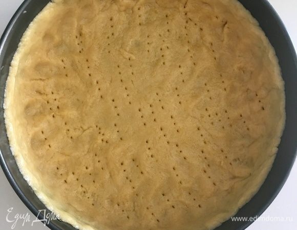 Перенести пласт теста аккуратно в разъемную форму, сформировать бортики. Часто-часто наколоть тесто вилочкой и убрать в морозильную камеру на час, пока готовим начинку.