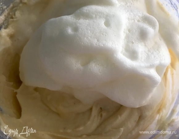 В самый последний момент начинаем вводить взбитые белки. Частями. И каждый раз с помощью венчика аккуратно, но уверенно, вручную вмешиваем белки. Движениями сверху вниз, протряхивая массу через венчик, вводим все белки. Наша задача — сделать творожную массу пышной, воздушной, точно облако!