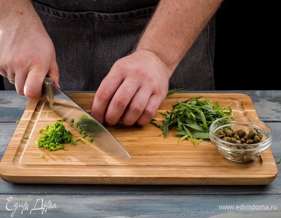 Мелко нарежьте лук и снятые со стеблей листья тархуна. Каперсы измельчите. 