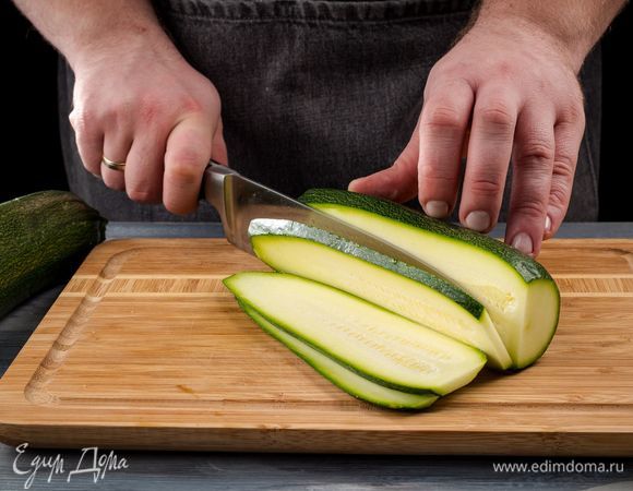 Помойте цукини и разрежьте их вдоль на пластинки (чистить не нужно) толщиной около 5 мм. Посолите и оставьте на 10 мин.