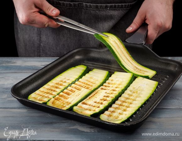 Дальше на сковороде гриль поджарьте нарезанные цукини с двух сторон. Готовые цукини выложите на тарелку с бумажным полотенцем, чтобы удалить лишний жир. Остудите.